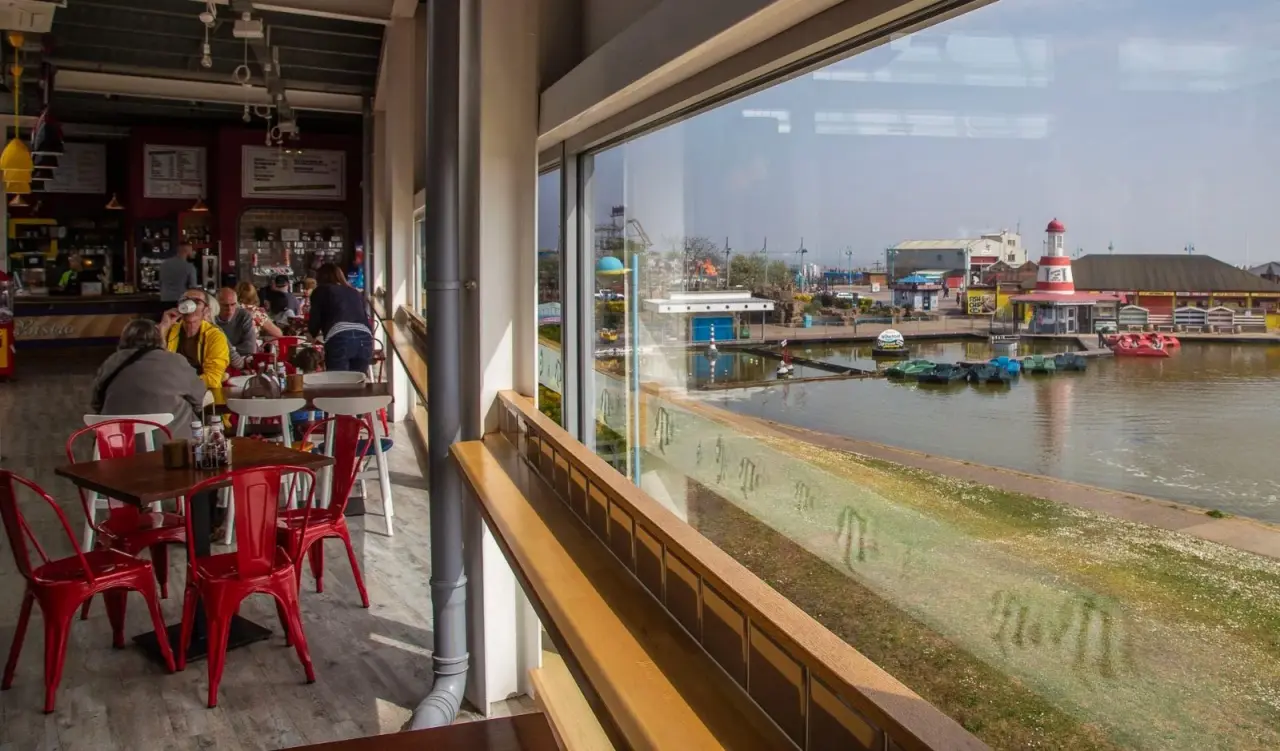 The Bistro's red chairs beside its long window over the boating lake