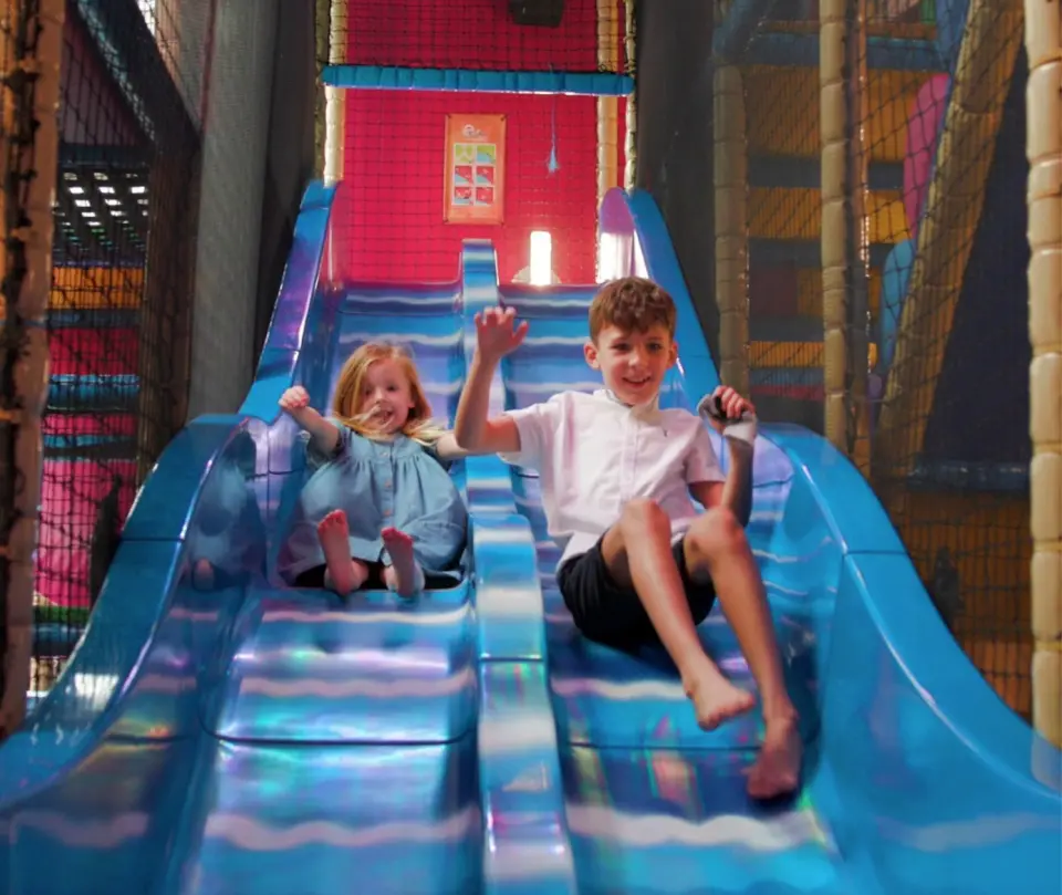 Children racing down the slides in Coral Cove soft play