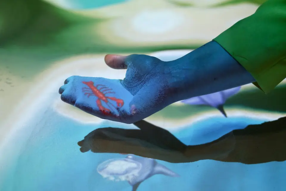 Hands playing in the interactive sandpit